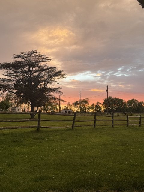 Sunset over the split-rail fence and fields