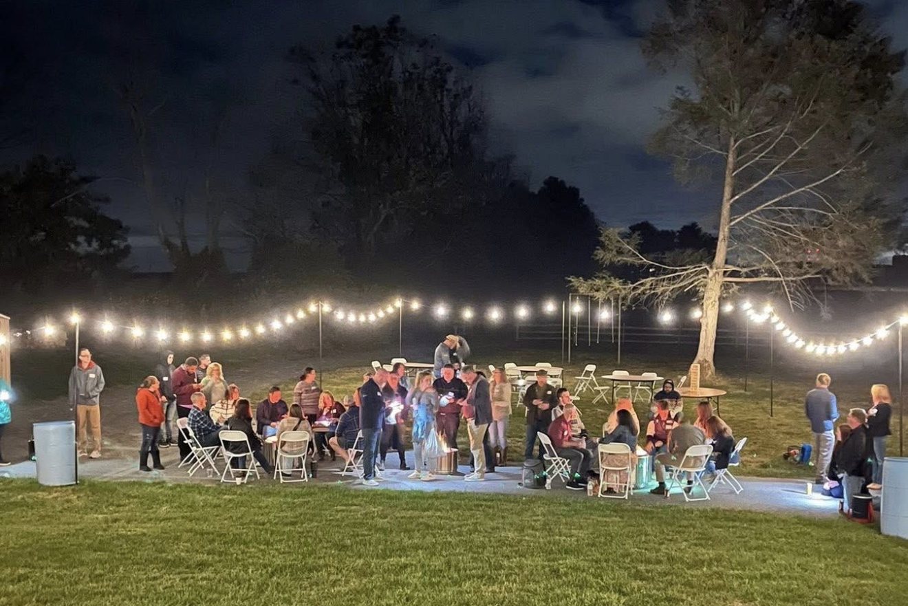 Guests gathered at a social evening under string lights